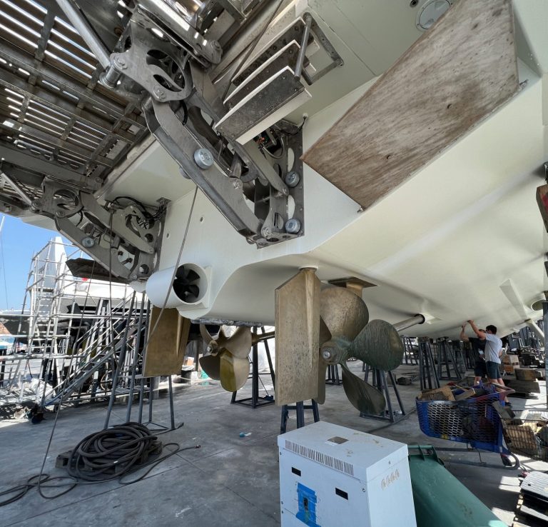 A boat's hull being maintained, with scaffolding and tools visible nearby.